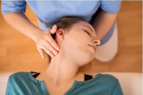 Chiropractor adjusting woman's neck, Lehigh Acres whiplash injury treatment