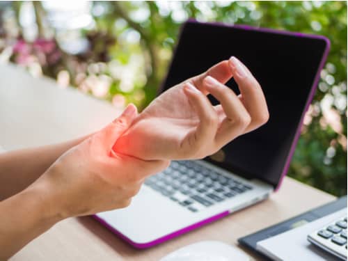 Concept of Pompano Beach carpal tunnel syndrome treatment, wrist pain using computer