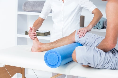 Boca Raton physiotherapy doctor examining man with leg injury
