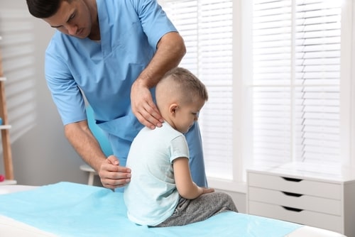 Chiropractor examining a child for Fort Lauderdale scoliosis treatment